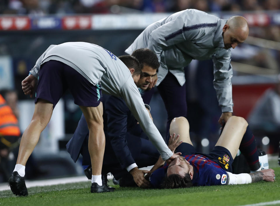 FC Barcelona's Lionel Messi receives medical attention after going down injured during the Spanish La Liga soccer match between FC Barcelona and Sevilla at the Camp Nou stadium in Barcelona, Spain, Saturday, Oct. 20, 2018. (AP Photo/Manu Fernandez)