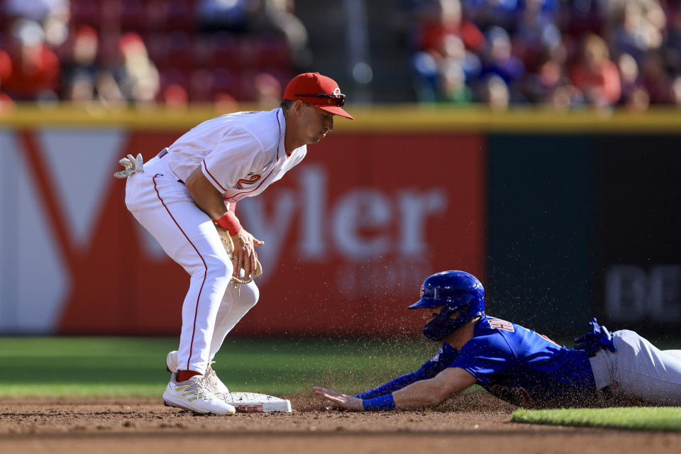 Cincinnati Reds' Spencer Steer, left, fields the ball as Chicago Cubs' Nico Hoerner steals second base during the second inning of a baseball game in Cincinnati, Friday, Wednesday, Oct. 5, 2022. (AP Photo/Aaron Doster)