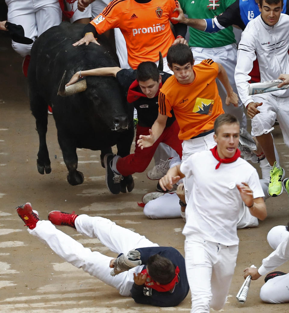 <p>Varios mozos corren ante un toro de la ganadería de Jandilla a la entrada de la Plaza de Toros de Pamplona, en el quinto encierro de los Sanfermines 2017 (EFE/Jesús Diges) </p>