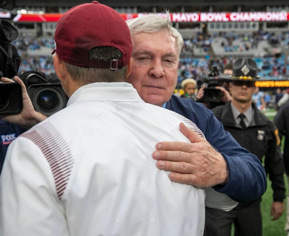 North Carolina coach Mack Brown embraces South Carolina coach Shane Beamer following the Gamecocks’ 38-21 victory over North Carolina on Thursday, December 30, 2021 at Bank of America Stadium in Charlotte, N.C.