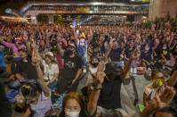 Anti-government protesters flash a three finger protest gesture during a rally Wednesday, Dec. 2, 2020, in Bangkok, Thailand. Thailand's highest court Wednesday acquitted Prime Minister Prayuth Chan-ocha of breaching ethics clauses in the country's constitution, allowing him to stay in his job.( AP Photo/Gemunu Amarasinghe)