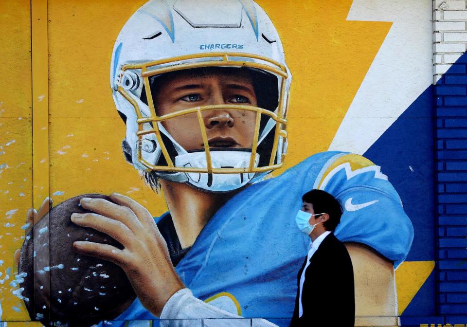 A mural of Chargers quarterback Justin Herbert decorates the exterior of a neighborhood market in Inglewood.