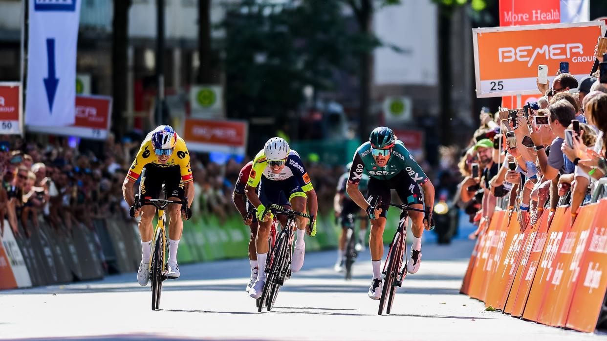  Wout van Aert of Belgium and two fellow riders race across the finish line at the Hamburg Cyclassics UCI World Tour event. 