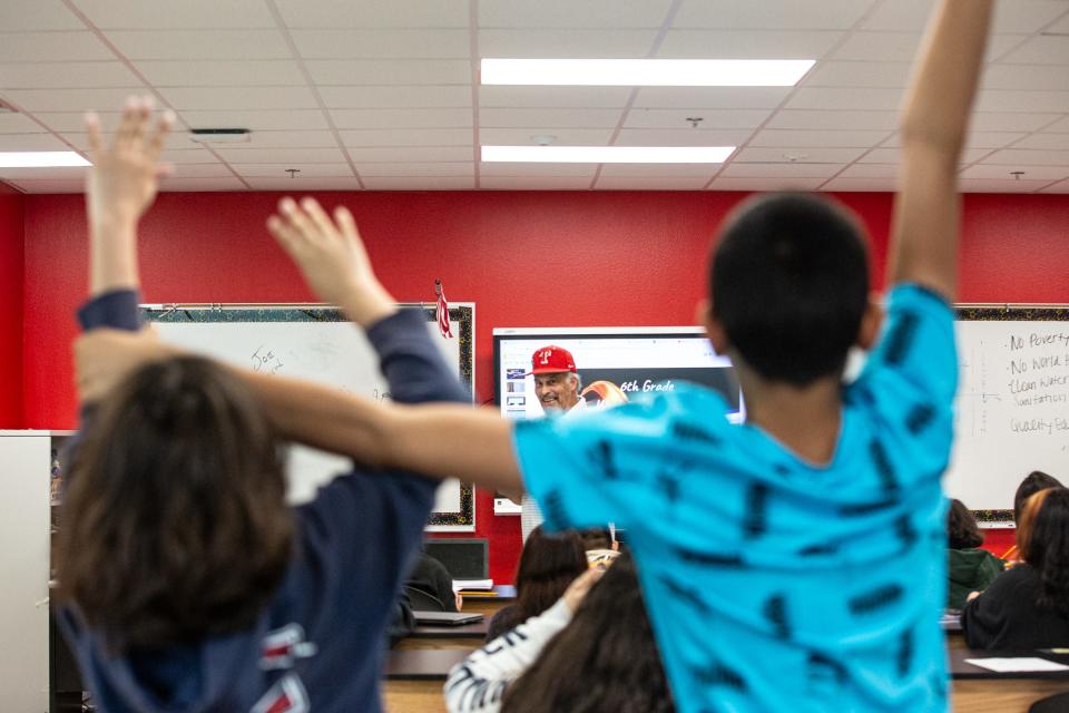 A student grabs a classmate's arm in attempt to put his hand down while vying to answer questions presented by teacher Ron Mendleski during a sixth-grade STEM class at Baker Middle School on Tuesday, June 20, 2023, in Corpus Christi, Texas.