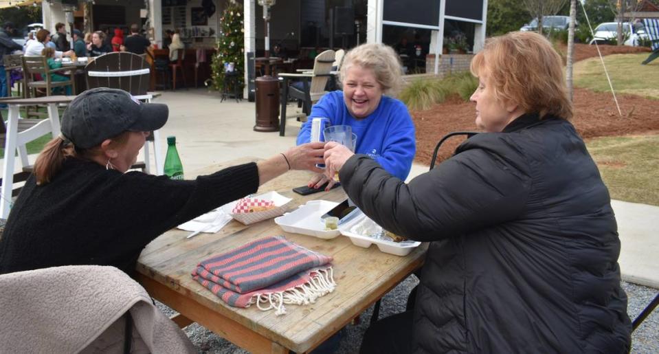 Susan Petra, Judy Vickery and Lynn Hoxworth (from left to right) share a beer at Red’s corner.