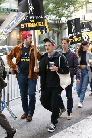 <p>Christopher Peterson / SplashNews</p> Ethan Slater walks a SAG-AFTRA picket line outside Warner Bros. in New York City on Oct. 16, 2023