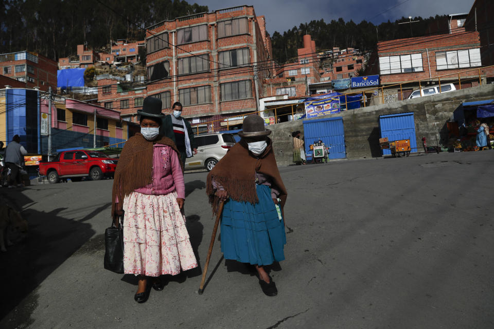 Mujeres caminan en una calle antes de la apertura de las mesas de votación en las elecciones generales en El Alto, Bolivia, el domingo 18 de octubre de 2020. (AP Foto/Juan Karita)