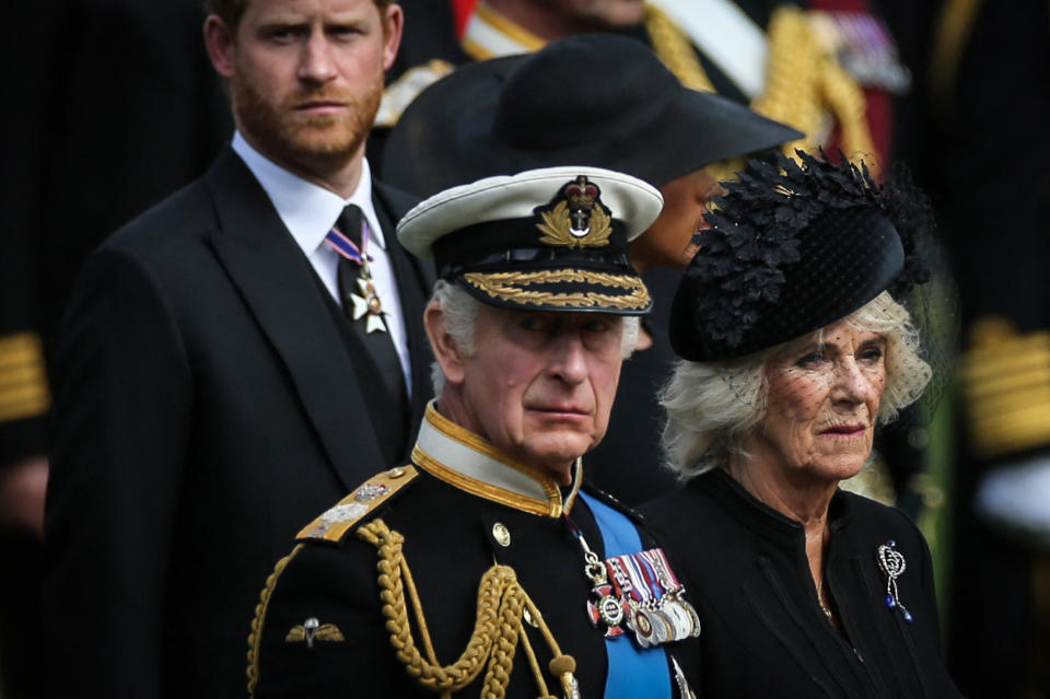 Britain's King Charles III (L), Britain's Camilla, Queen Consort and Britain's Prince Harry, Duke of Sussex look at members of the Bearer Party transferring the coffin of Queen Elizabeth II, draped in the Royal Standard, form the State Gun Carriage of the Royal Navy into the State Hearse at Wellington Arch in London on September 19, 2022, after the State Funeral Service of Britain's Queen Elizabeth II. (Photo by ISABEL INFANTES / POOL / AFP) (Photo by ISABEL INFANTES/POOL/AFP via Getty Images)