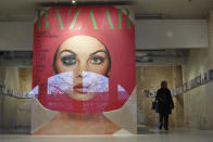 A visitor walks by a giant cover from Harper's Bazar magazine as part of the exhibition « Harper's Bazaar, First in Fashion » at the The Musée des Arts Décoratifs, in Paris, Thursday, Feb. 27, 2020. The Musée des Arts Décoratifs is re-opening its entirely renovated 1,300 square meter Fashion Galleries, the world's largest fashion exhibition space. (AP Photo/Thibault Camus)
