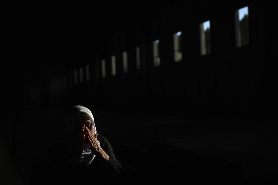 A Bosnian muslim woman mourns next to the coffin containing the remains of her family member who is among 50 newly identified victims of Srebrenica Genocide in Potocari, Bosnia, Sunday, July 10, 2022. Thousands converge on the eastern Bosnian town of Srebrenica to commemorate the 27th anniversary on Monday of Europe's only acknowledged genocide since World War II. (AP Photo/Armin Durgut)