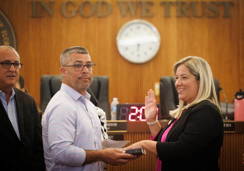 Melinda De La Vega (a la derecha) siendo juramentada como nueva concejal interina por su esposo durante una reunión del concejo municipal el martes 16 de julio de 2024, en el Ayuntamiento de Hialeah.