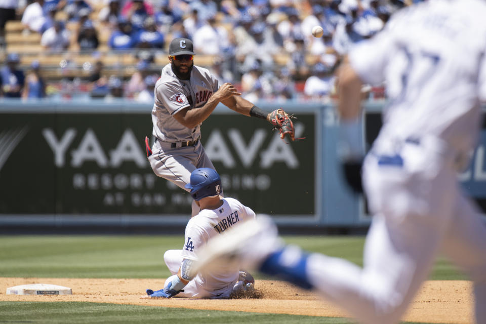 Cleveland Guardians shortstop Amed Rosario turns a double play over the slide by Los Angeles Dodgers' Justin Turner during the fourth inning of a baseball game in Los Angeles, Sunday, June 19, 2022. Los Angeles Dodgers' Eddy Alvarez was out at first. (AP Photo/Kyusung Gong)