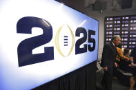 Atlanta Falcons owner Arthur Blank walks by a monitor displaying a 2025 logo following a press conference at Mercedes-Benz Stadium, Tuesday, Aug. 16, 2022, in Atlanta, announcing that the CFP National Championship NCAA college football game will be played at Mercedes-Benz Stadium in 2025. (Jason Getz/Atlanta Journal-Constitution via AP)