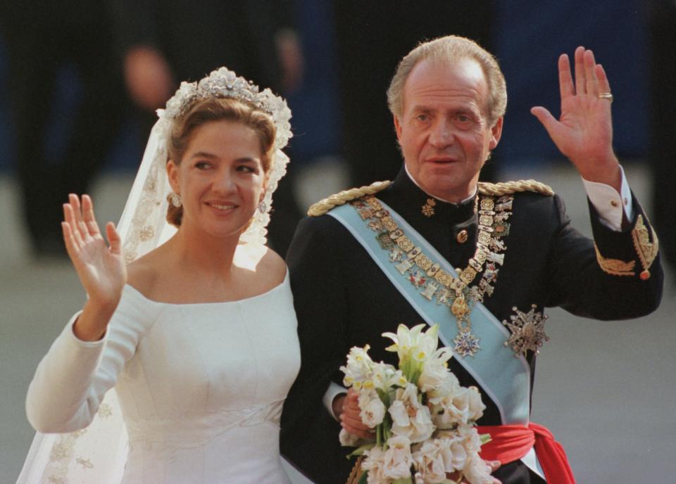 In this Oct. 4, 1997 file photo, Spain's Princess Cristina, left is escorted to the Barcelona cathedral by her father King Juan Carlos prior to getting married to Inaki Urdangarin. In an unprecedented court appearance on Saturday Feb. 8, 2014 for a direct descendent of a Spanish king, Princess Cristina will answer questions from a judge who has formally named her as a fraud and money laundering suspect. The case is a direct offshoot of one led by the same judge in an investigation of her husband Inaki Urdangarin for allegedly using his position as the Duke of Palma to embezzle public contracts via the Noos Institute, a supposedly nonprofit foundation he set up that channeled money to other businesses. Spain’s royal family just wants the case that has now dragged on for years to end rapidly so the monarchy can try to rebuild the trust it once had. (AP Photo/Armando Franca, File)