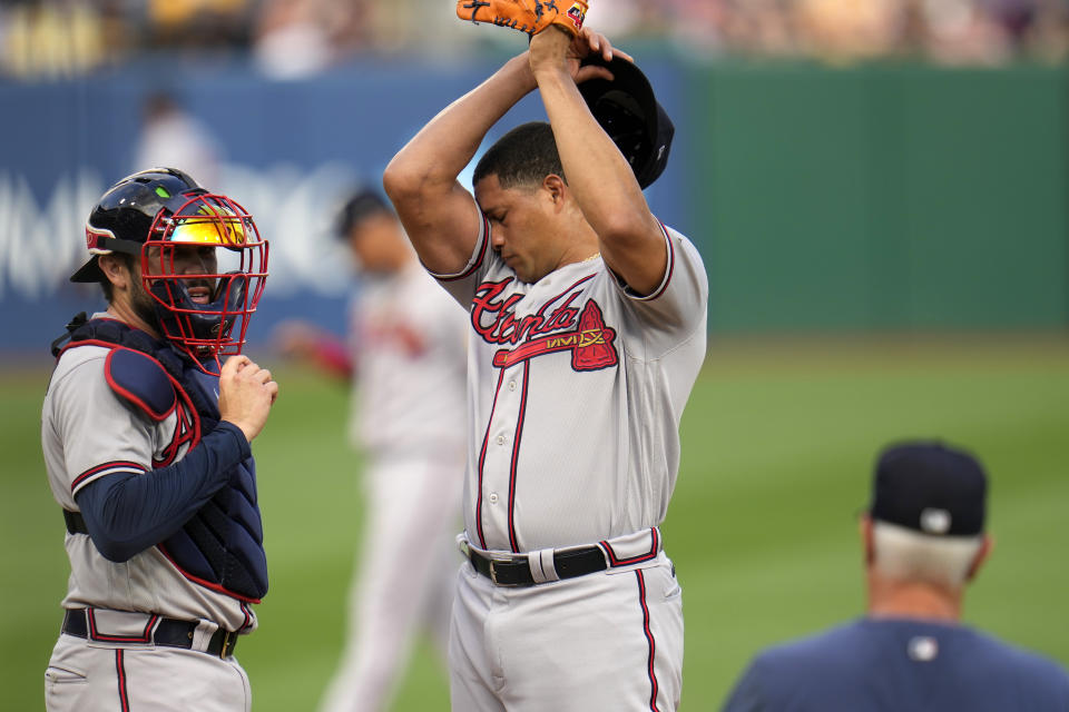 Atlanta Braves starting pitcher Yonny Chirinos, center, and catcher Travis d'Arnaud, left, wait for a visit from pitching coach Rick Kranitz during the first inning of the team's baseball game against the Pittsburgh Pirates in Pittsburgh, Tuesday, Aug. 8, 2023. (AP Photo/Gene J. Puskar)