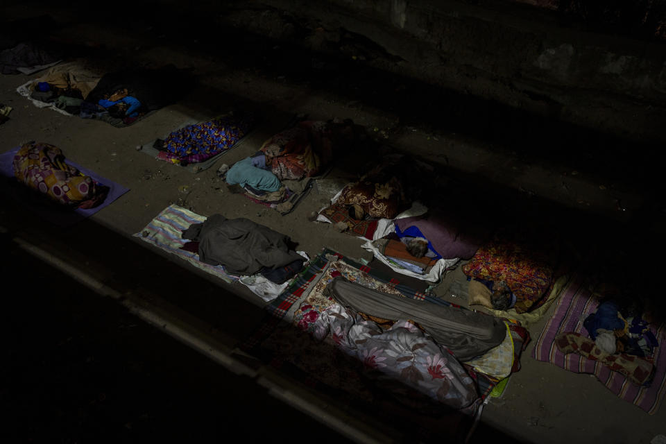 Homeless people sleep in the open under an overpass on a winter night in New Delhi, Dec. 28, 2022. India’s 2011 census figures show about 47,000 of the city’s residents were sleeping homeless, but activists say the number is a vast underestimate and that New Delhi has more than 150,000 rough sleepers. The harsh winter is blamed for killing scores of homeless people and leaving tens of thousands of others shivering on the streets. (AP Photo/Altaf Qadri)