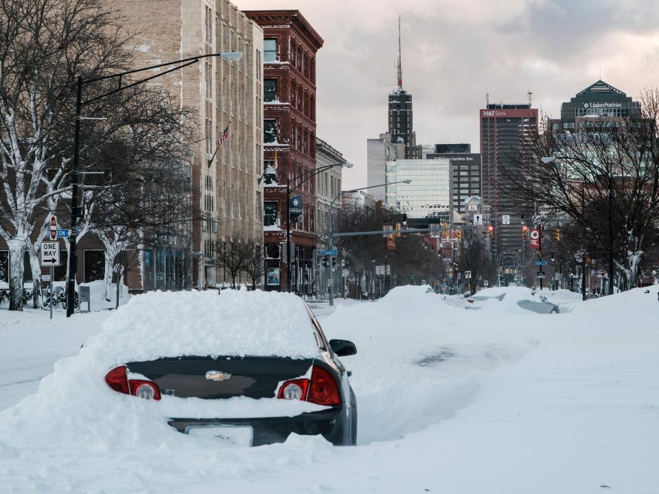 An abandoned vehicle is left under heavy snow along a street in Buffalo, New York, on December 25, 2022.