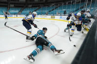 San Jose Sharks left wing Rudolfs Balcers (92) falls in front of St. Louis Blues center Brayden Schenn, right front, during the second period of an NHL hockey game in San Jose, Calif., Saturday, Feb, 27, 2021. (AP Photo/Tony Avelar)