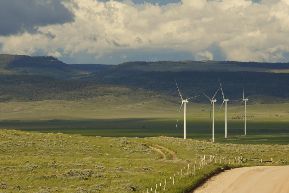 Clouds cast shadows near wind turbines at a wind farm along the Montana-Wyoming state line on Monday, June 13, 2022. The rush to build wind farms to combat climate change is colliding with preservation of one of the U.S. West's most spectacular predators, the golden eagle. Scientists say the species is teetering on the edge of decline and worry that proliferating wind turbines could push them over the brink. (AP Photo/Emma H. Tobin)