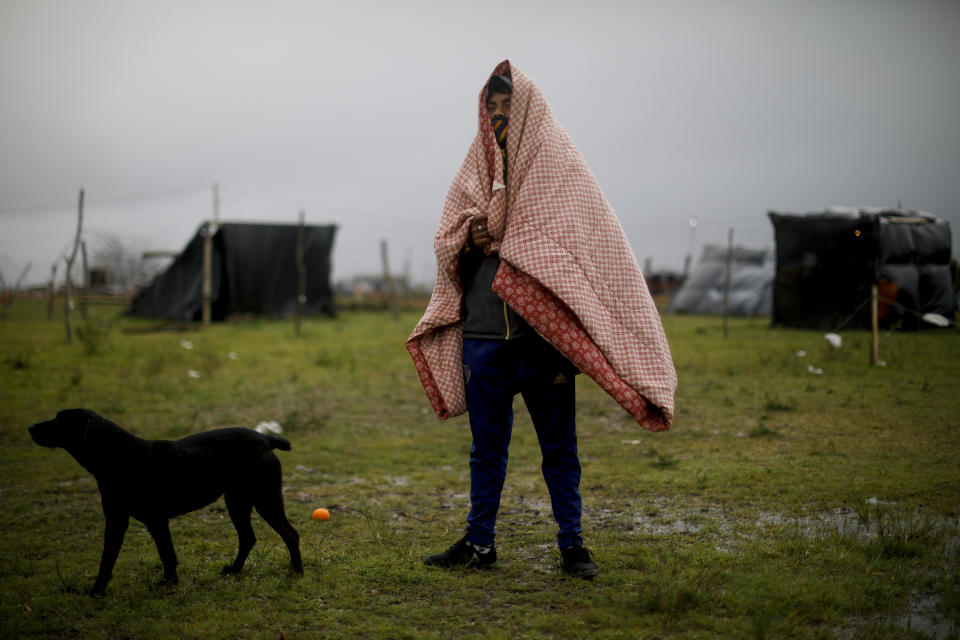 Darío Rodríguez se para afuera de su casa improvisada en un campamento ocupado ilegalmente en Guernica, provincia de Buenos Aires, Argentina, el domingo 27 de septiembre de 2020. Argentina reportó el miércoles que la pobreza subió al 40,9% en el primer semestre del año, un aumento del 5,4% respecto de igual período del año pasado. (AP Foto/Natacha Pisarenko)