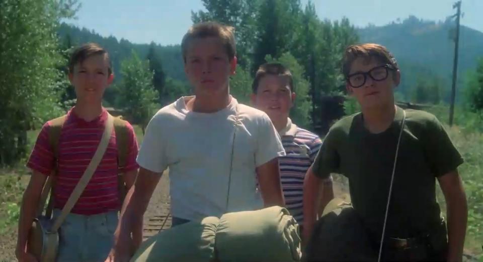 Gordie, Chris, Teddy, and Vern walking on the train tracks in "Stand By Me"