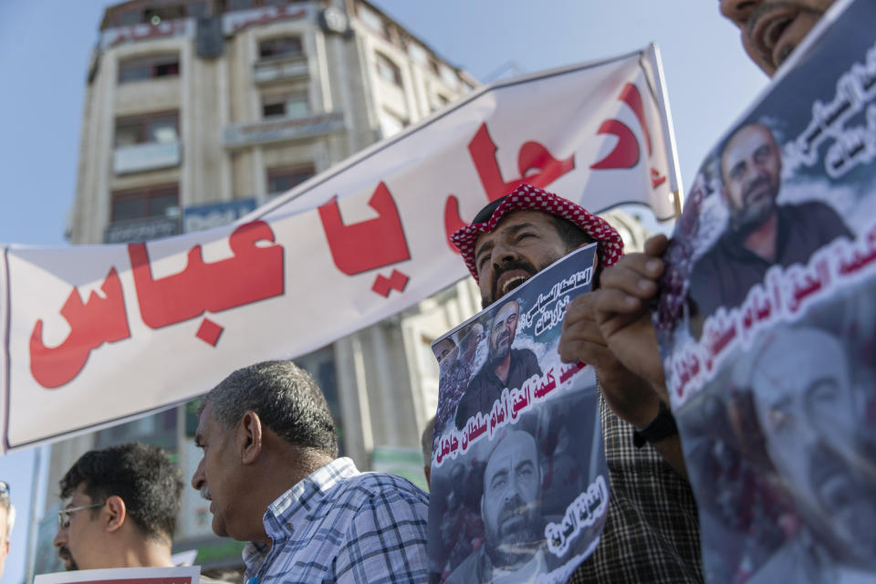 Demonstrators carry posters with pictures of Palestinian Authority outspoken critic Nizar Banat that reads "a Martyr of saying the truth in front of an ignorant Sultan," and a banner that reads "Abbas, leave," during a rally protesting his death, in the West Bank city of Ramallah, Saturday, July 3, 2021. Hundreds of Palestinians gathered to demonstrate against President Mahmoud Abbas, hoping to inject new momentum into a protest movement sparked by the death of an outspoken critic in the custody of security forces. (AP Photo/Nasser Nasser)