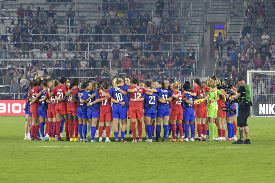 Members of the U.S. and Canadian teams meet on the field before a SheBelieves Cup soccer match Thursday, Feb. 16, 2023, in Orlando, Fla. (AP Photo/Phelan M. Ebenhack)