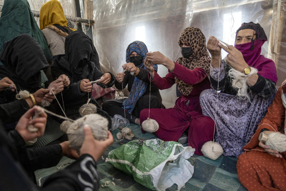 Afghan women weave wools for making carpets at a traditional carpet factory in Kabul, Afghanistan, Monday, March 6, 2023. After the Taliban came to power in Afghanistan, women have been deprived of many of their basic rights. (AP Photo/Ebrahim Noroozi)