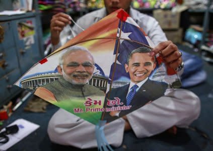 An employee ties threads on a kite, with portraits of Indian Prime Minister Narendra Modi (L) and U.S. President Barack Obama, ahead of Obama's visit, in Mumbai January 23, 2015. REUTERS/Danish Siddiqui