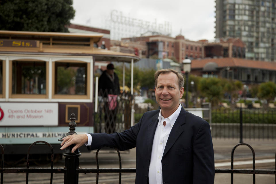In this photo taken Thursday, Oct. 25, 2012, Michael Ellis, the new worldwide director of Michelin Guide, poses by the Hyde Street cable car turnaround and Ghirardelli Square near Fisherman's Wharf in San Francisco. Ellis took over this year as head of the guides, becoming the first U.S.-born (and first non-Frenchman) to head the Michelin Guide. (AP Photo/Eric Risberg)