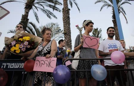 Protesters hold signs in support of the wedding of groom Mahmoud Mansour, 26, and bride Maral Malka, 23, outside a wedding hall in Rishon Lezion, near Tel Aviv August 17, 2014. REUTERS/Ammar Awad