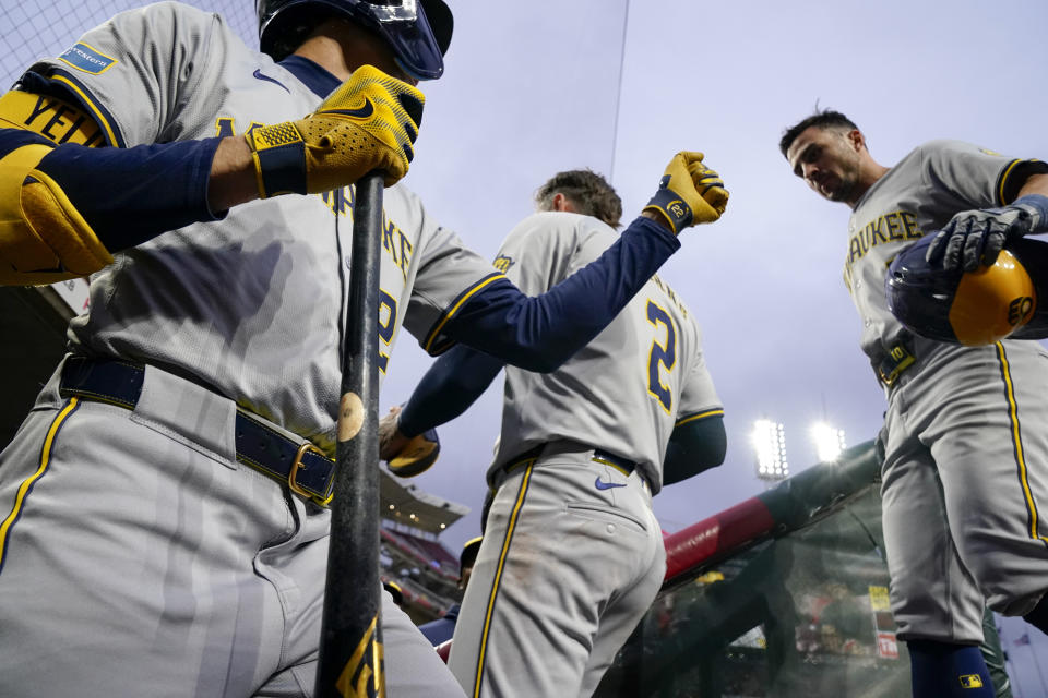 Milwaukee Brewers' Sal Frelick, right, celebrates with Christian Yelich, left, after scoring on a single by Blake Perkins against the Cincinnati Reds during the third inning of a baseball game Tuesday, April 9, 2024, in Cincinnati. (AP Photo/Jeff Dean)