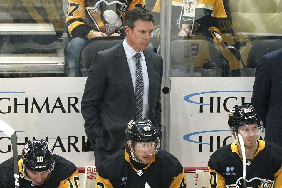 Pittsburgh Penguins head coach Mike Sullivan, center top, stands behind the bench during the first period of an NHL hockey game against the New York Islanders, Sunday, Dec. 31, 2023, in Pittsburgh. (AP Photo/Matt Freed)