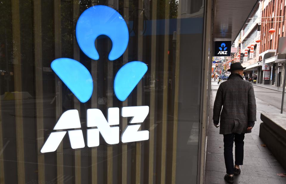 A man walks past an ANZ bank sign in Melbourne's Chinatown on April 30, 2020. - Australia's ANZ Bank announced a 50-percent dive in after-tax profits, as the lender set aside one billion Australia dollars (655 million US) to cover expected losses resulting from the coronavirus fallout. (Photo by William WEST / AFP) (Photo by WILLIAM WEST/AFP via Getty Images)