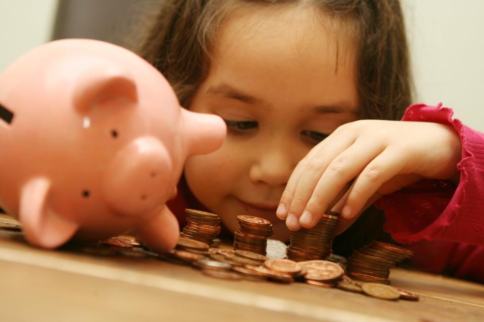 A child with a piggy bank (PA Archive)