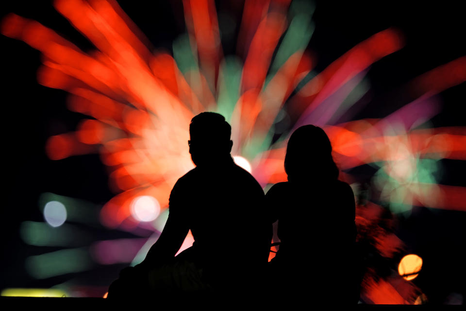 FILE - People watch distant fireworks from a park on July 4, 2022, in Kansas City, Mo. Warehouse membership club Costco said it would be closed on July 4th, 2024, but the vast majority of major national retailers will be open, with some offering promotional sales to lure customers. (AP Photo/Charlie Riedel, File)