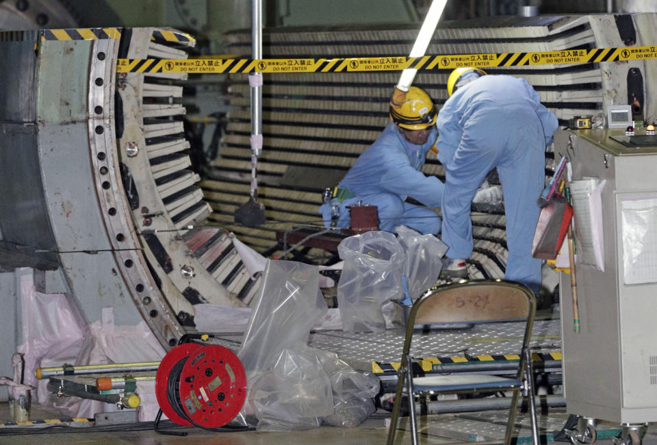 In this Nov. 28, 2018, photo, workers dismantle the Unit 2 reactor at Chubu Electric Power Co.,'s Hamaoka nuclear power plant in Omaezaki, Shizuoka prefecture. Japan's nuclear policy-setting body has adopted a report saying the country is entering an era of massive nuclear plant decommissioning, urging operators to plan ahead to lower safety risks and costs on work requiring decades and billions of dollars. (Kyodo News via AP, File)