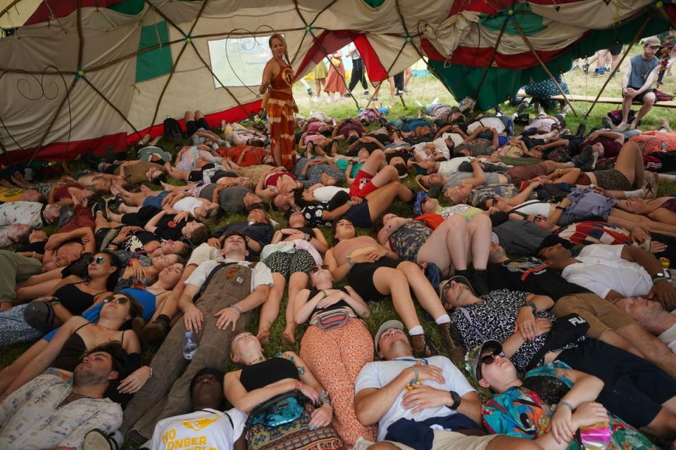 Festival-goers take part in a laughter - yoga workshop in the Healing Field (PA)