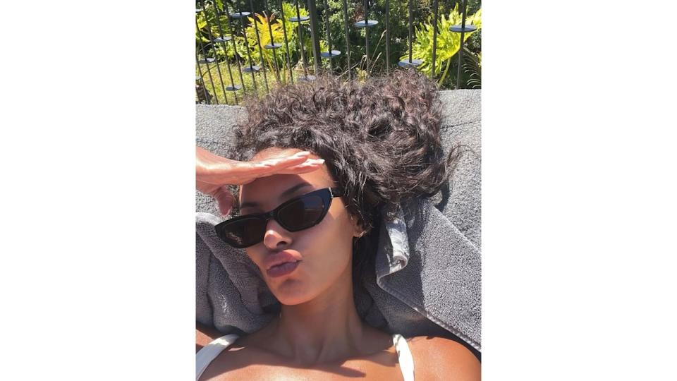 Maya Jama with natural curls by pool 