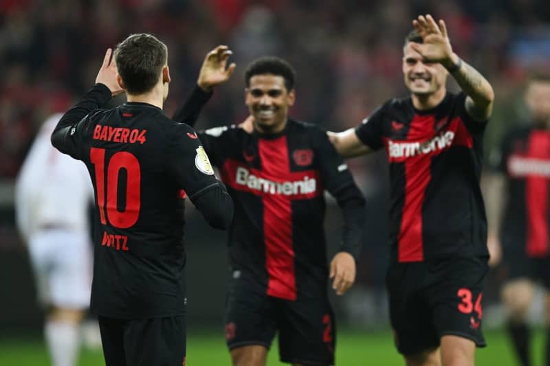 Leverkusen's Florian Wirtz (L) celebrates scoring his side's third goal with teammates Amine Adli and Granit Xhaka during the German DFB Cup semi final soccer match between Bayer Leverkusen and Fortuna Duesseldorf at BayArena. Marius Becker/dpa