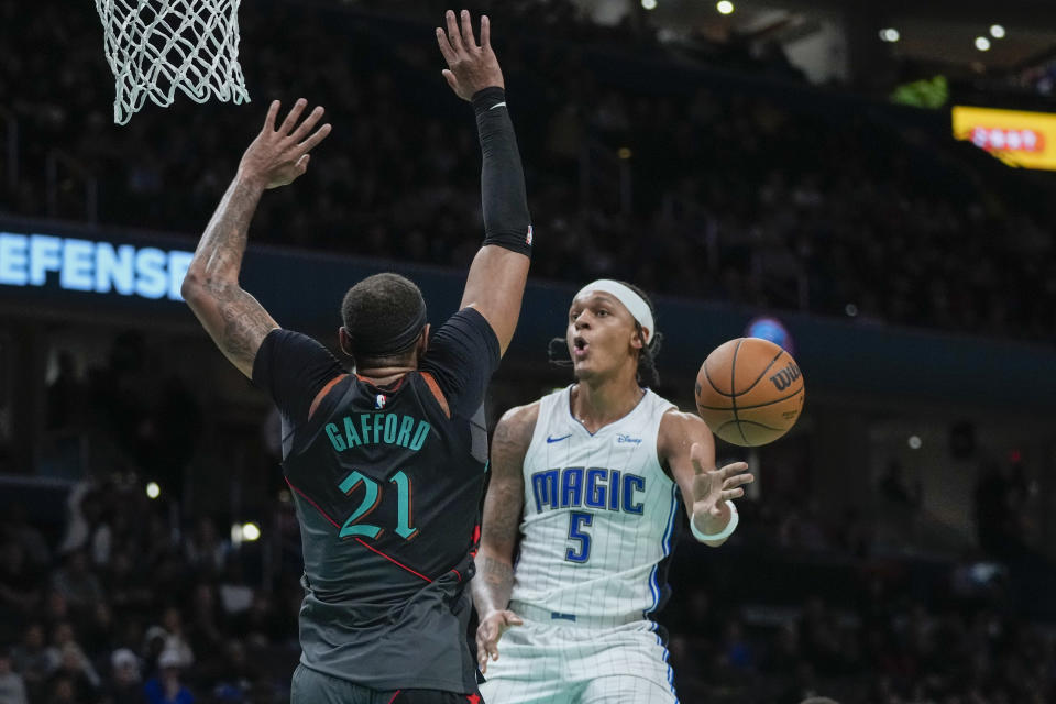 Orlando Magic forward Paolo Banchero (5) passes the ball in front of Washington Wizards center Daniel Gafford (21) during the second half of an NBA basketball game, Tuesday, Dec. 26, 2023, in Washington. (AP Photo/Alex Brandon)