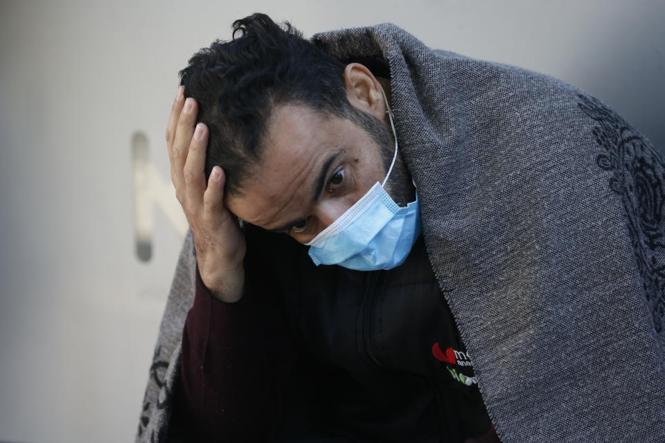 A local resident, staying outdoors for fear of aftershocks, pauses as he watches members of rescue services search for survivors in the debris of a collapsed building in Izmir, Turkey, Sunday, Nov. 1, 2020. Rescue teams continue ploughing through concrete blocs and debris of collapsed buildings in Turkey's third largest city in search of survivors of a powerful earthquake that struck Turkey's Aegean coast and north of the Greek island of Samos, Friday Oct. 30, killing dozens Hundreds of others were injured.(AP Photo/Darko Bandic)