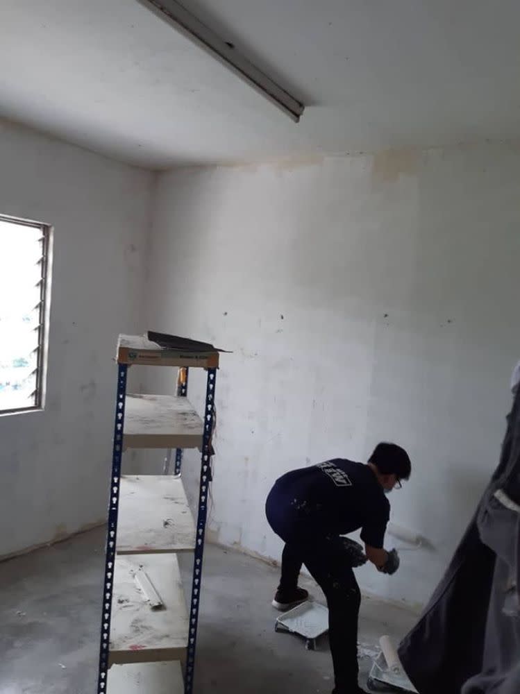 A Dana Kita volunteer paints the walls of the flat.