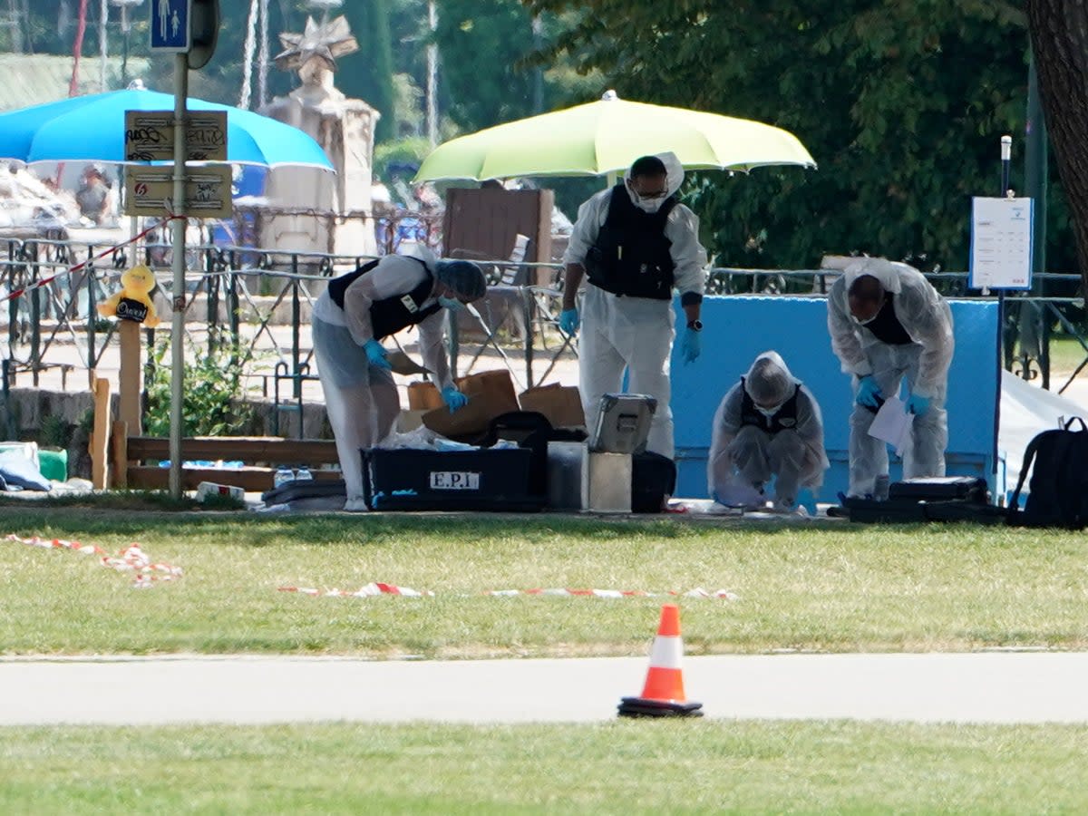 Forensics officers investigate at the scene (AP)