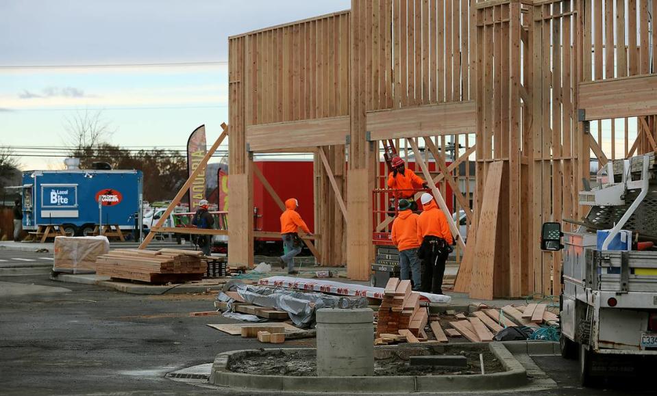 Construction crews work on framing the building for the new Tropic Hunger restaurant on West Okanogan Avenue adjacent to the Edison Food Park.