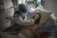 FILE - In this Feb. 2, 2021, file photo, a nurse cleans a patient suffering from COVID-19 in the ICU at the La Timone hospital in Marseille, southern France. The global death toll from the coronavirus topped a staggering 3 million people Saturday, April 17, 2021, amid repeated setbacks in the worldwide vaccination campaign and a deepening crisis in places such as Brazil, India and France. (AP Photo/Daniel Cole, File)