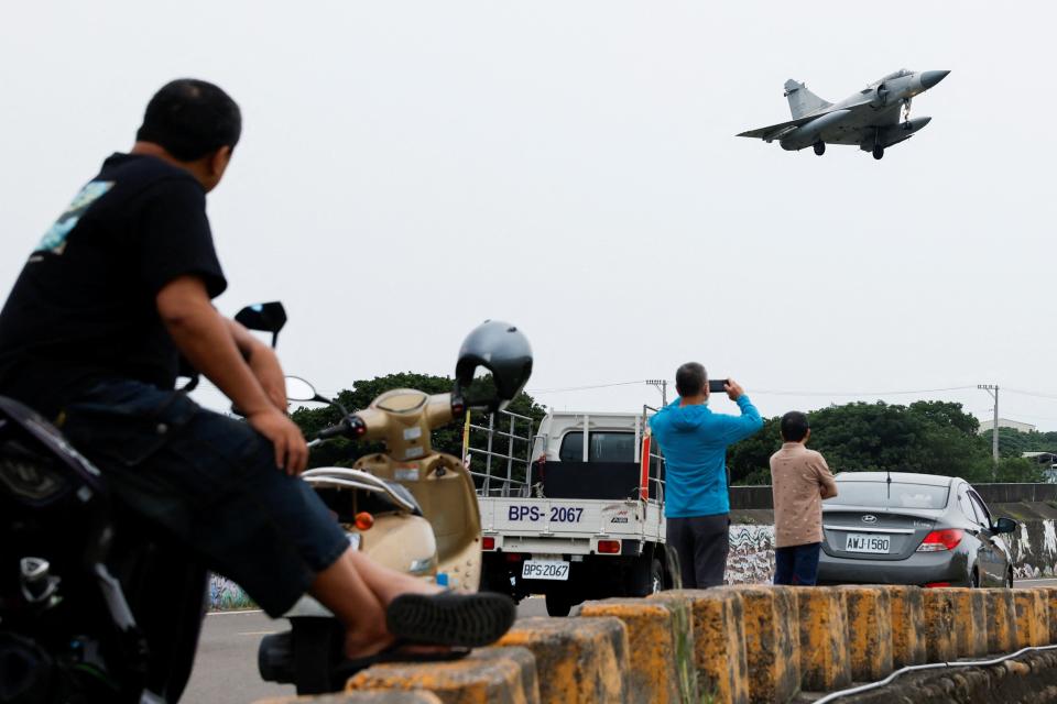 People look at a Taiwan Air Force Mirage 2000-5 aircraft as it prepares to land at Hsinchu Air Base in Hsinchu, Taiwan 23 May 2024 (Reuters)
