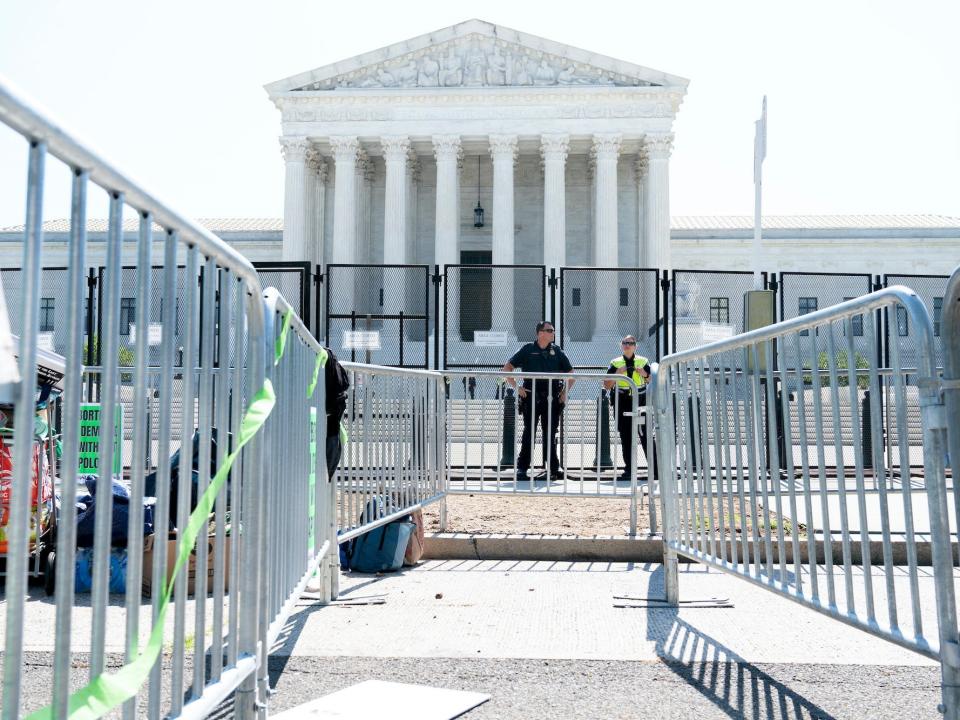 Security works by fencing outside the Supreme Court, Wednesday, June 15, 2022, in Washington