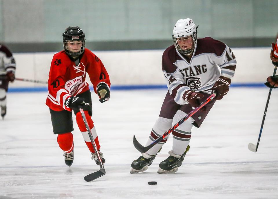 Old Rochester's Heather Lapworth attempts to backcheck Bishop Stang's Emily Curran as she carries the puck into the Old Rochester end of the ice during the second period of Wednesday.