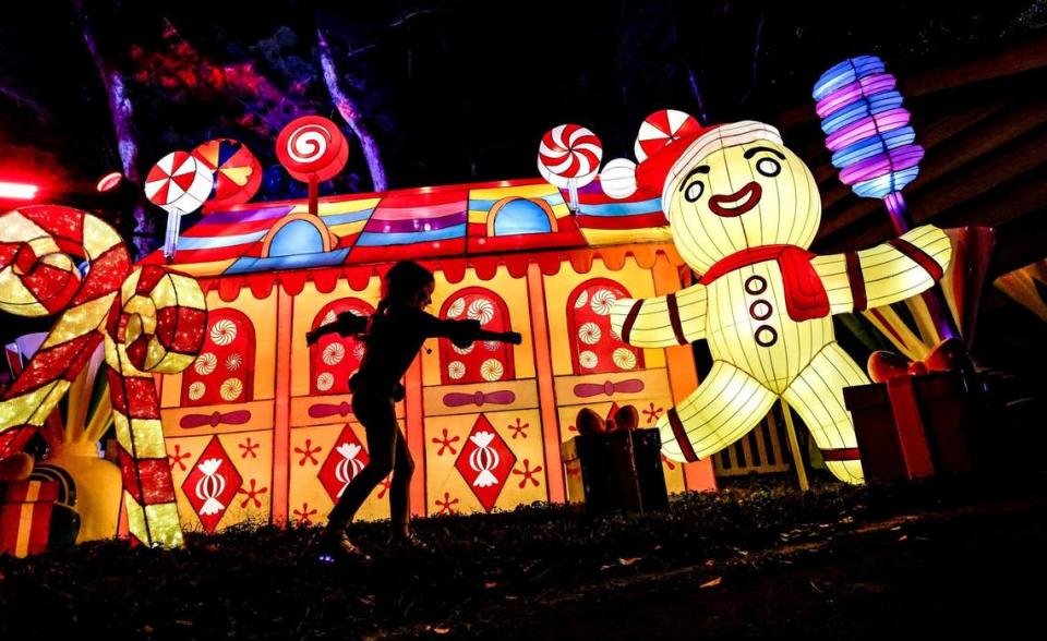 Sky Levine, 5, dances in front of the Gingerbread House display on SweetStreet along Tinsel Trail during Christmas Wonderland’s opening night at Tropical Park in Miami on Friday, November 17, 2023.